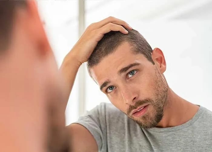 Man Checking his Hair on Mirror | Reclaim Men's Clinic in St. Louis, MO